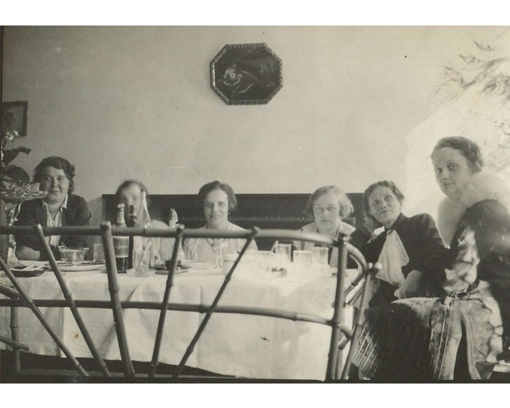 Biesiada sześciu osób za stołem nakrytym białym obrusem