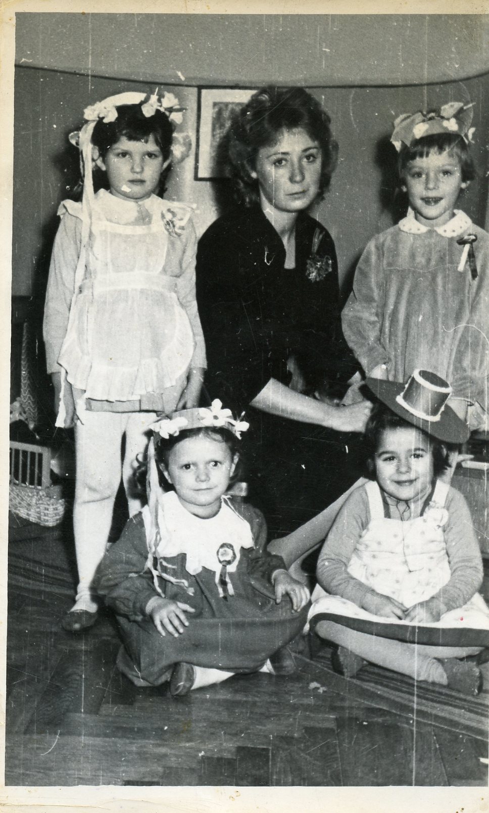 czwórka dzieci w nakryciach głowy a w środku nauczycielka przedszkolna