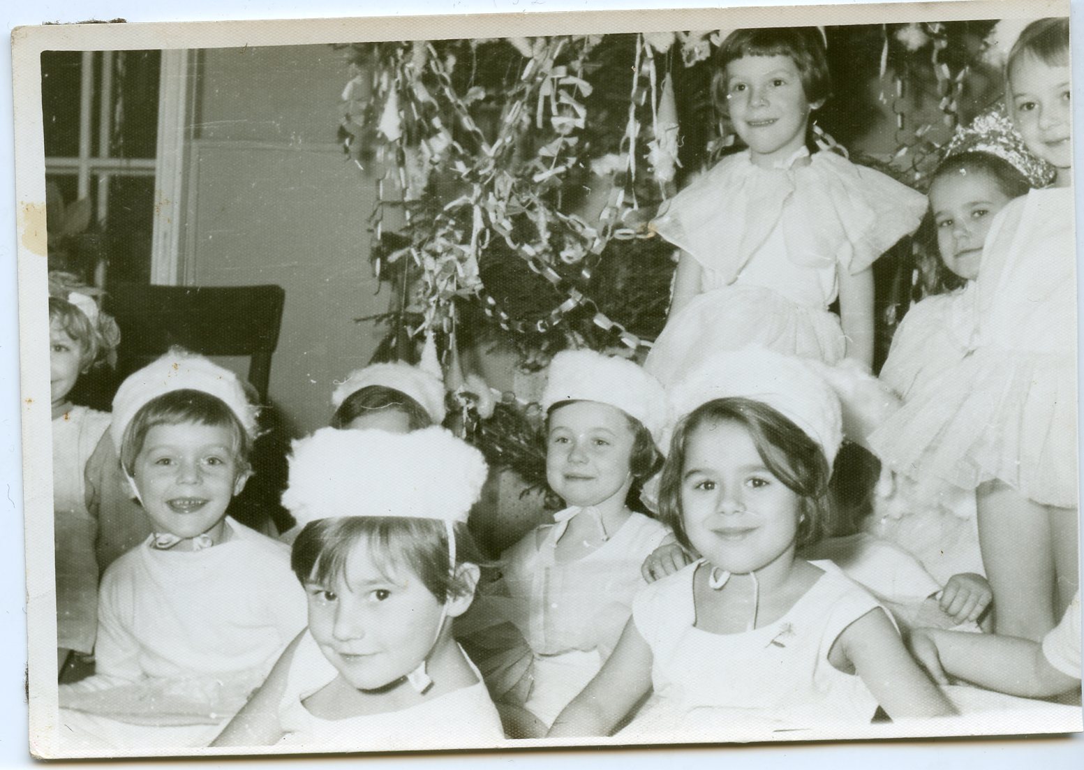 przedszkolaki ubrane na biało przed choinką bożonarodzeniową