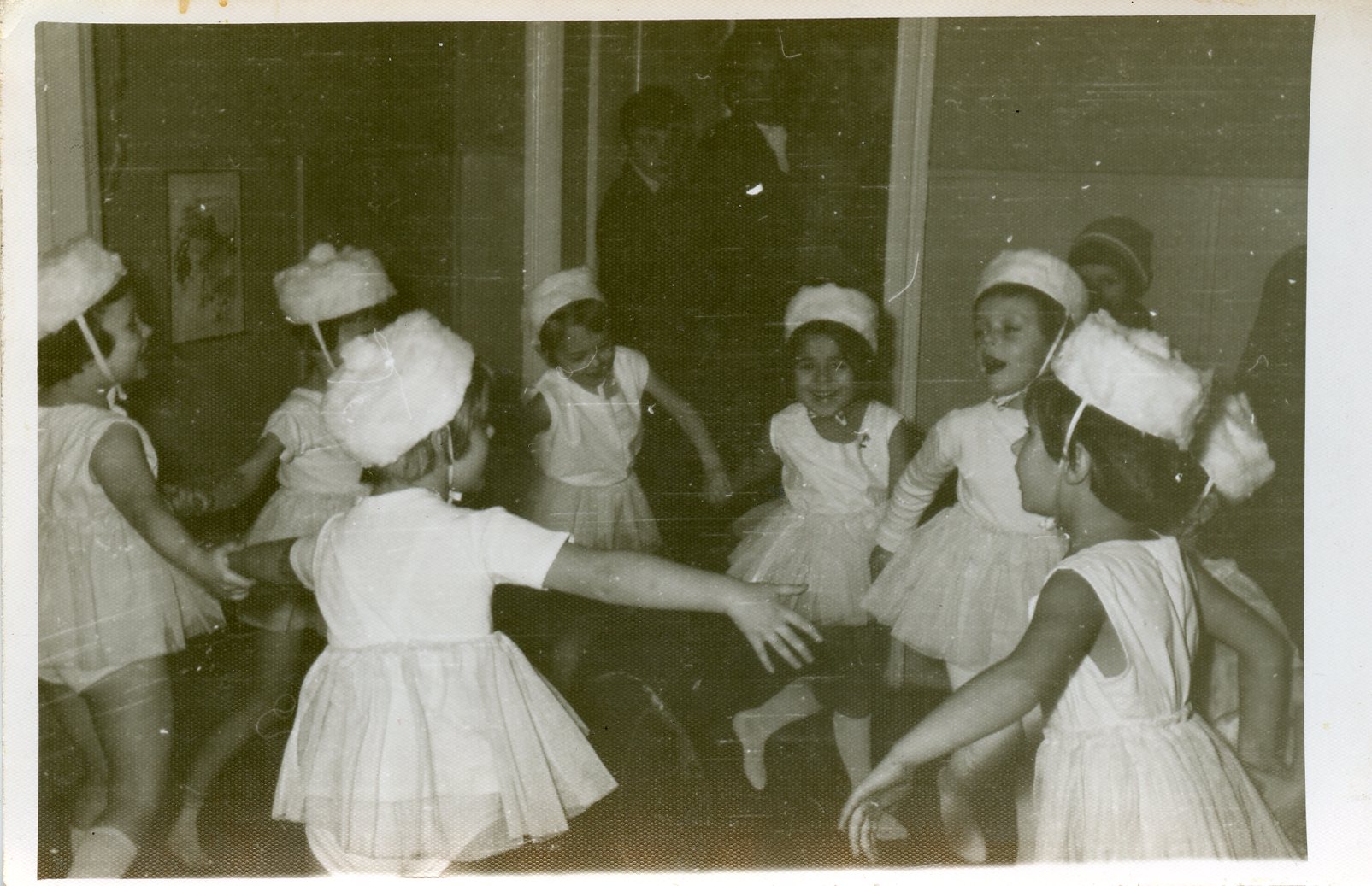 Tańczące w kółku przedszokalki ubrane na biało