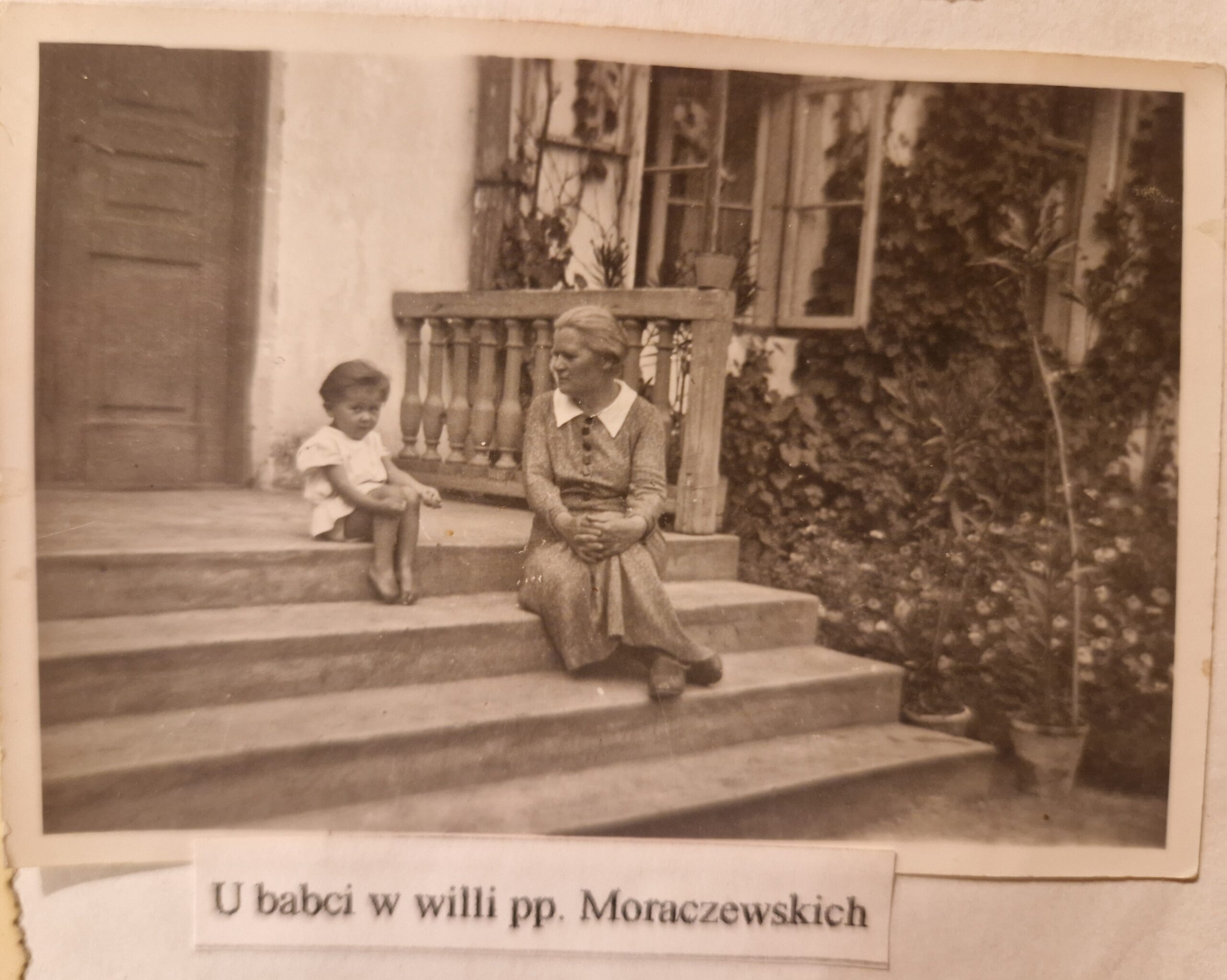 Anna Basara siedząca przed domem dworku Siedziba z babcią
